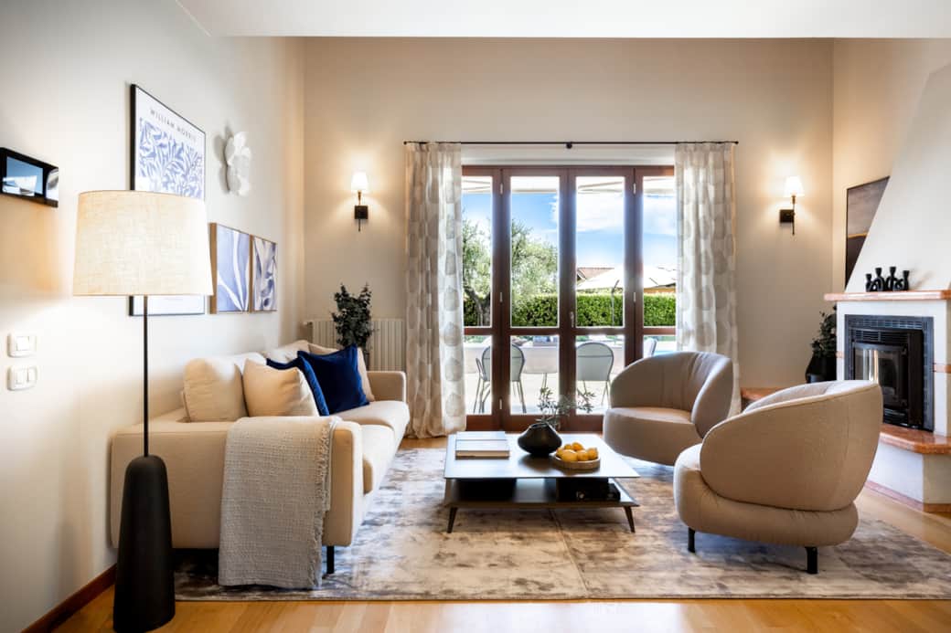 Offener Wohnbereich mit Kamin und direktem Zugang zum Pool und zur Veranda.