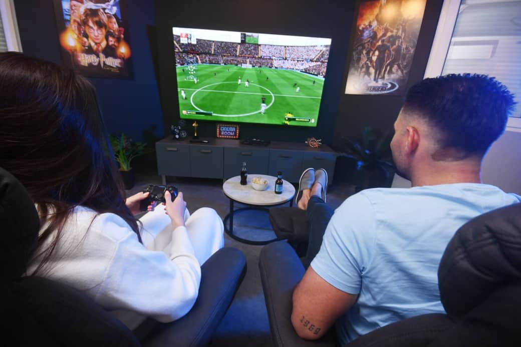 Salon immersif avec grand écran et espace repas convivial.
