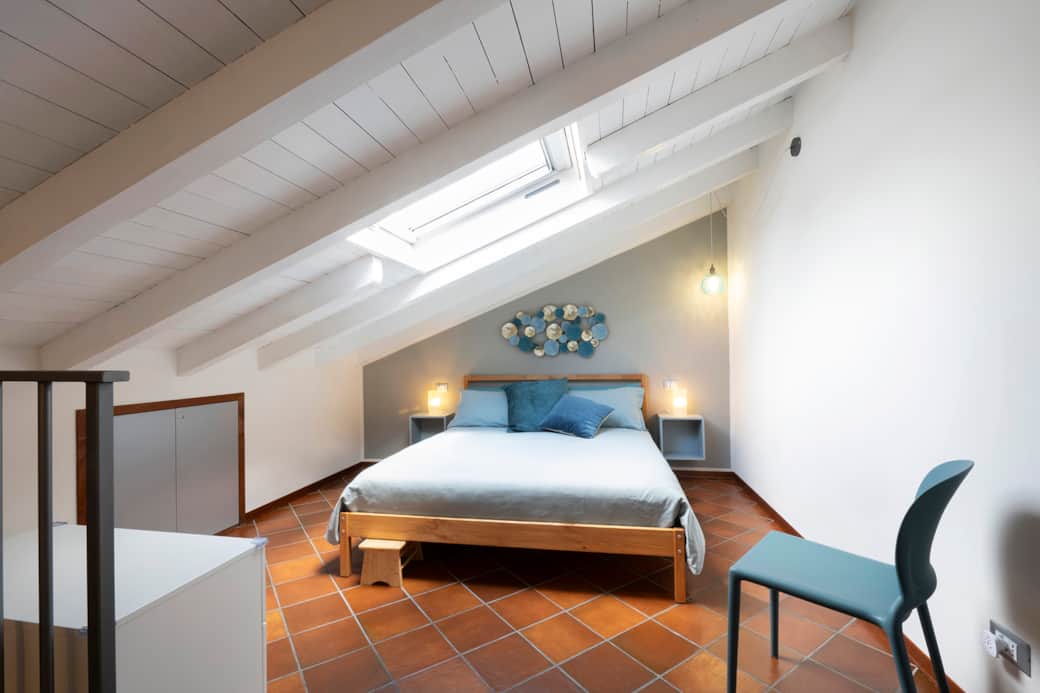 Under the window that gives the house its name, the main bedroom comes to life in the attic.