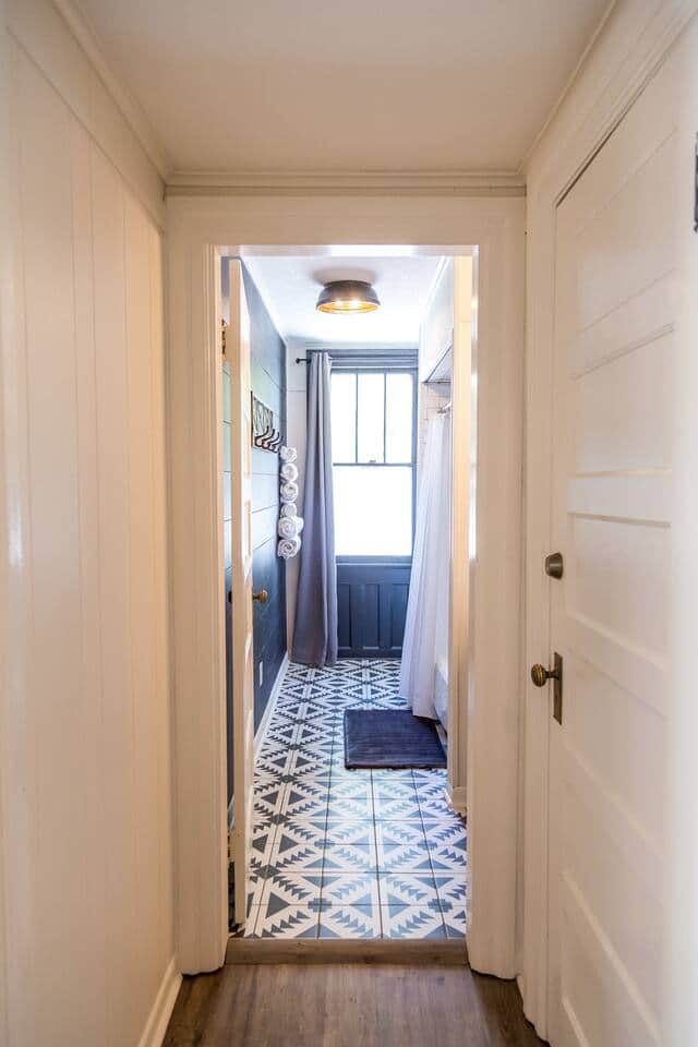Bathroom includes beautiful flooring, along with a vanity, toilet and a tub/shower combo.