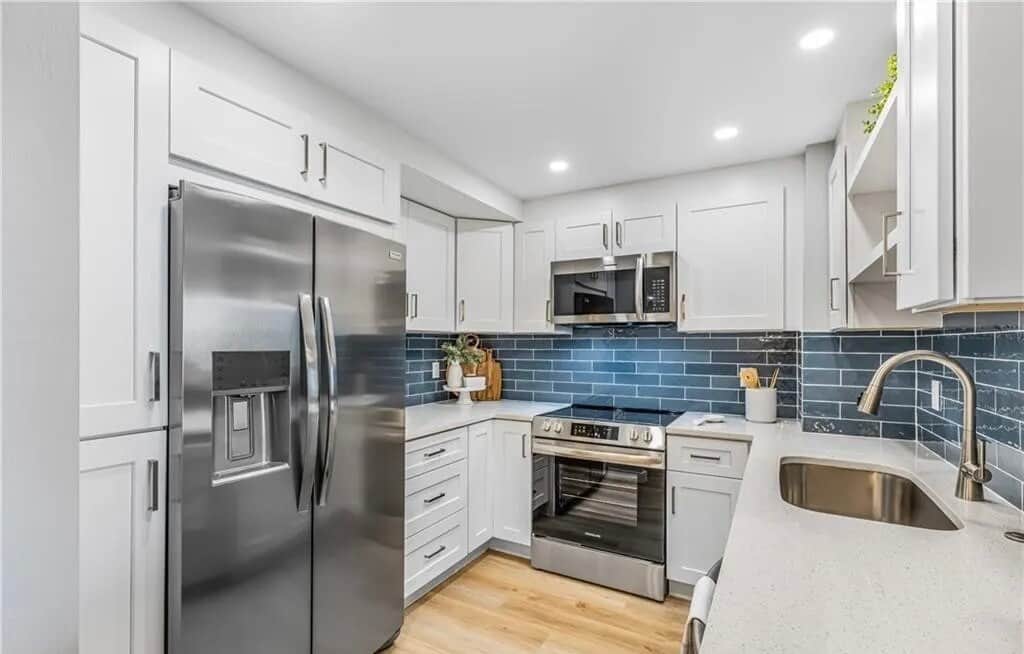 Fully equipped renovated kitchen with stainless appliances, generous counter space and coastal finishes.