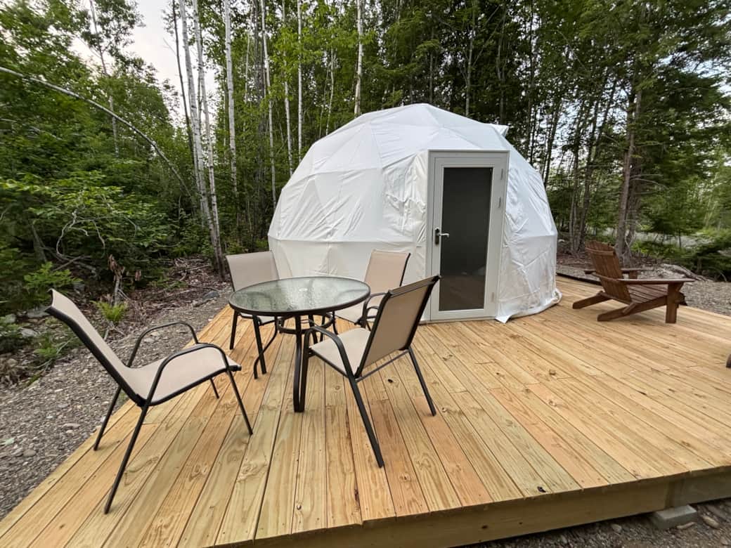 Dome 1 Entrance with dining table and Adirondack chairs.