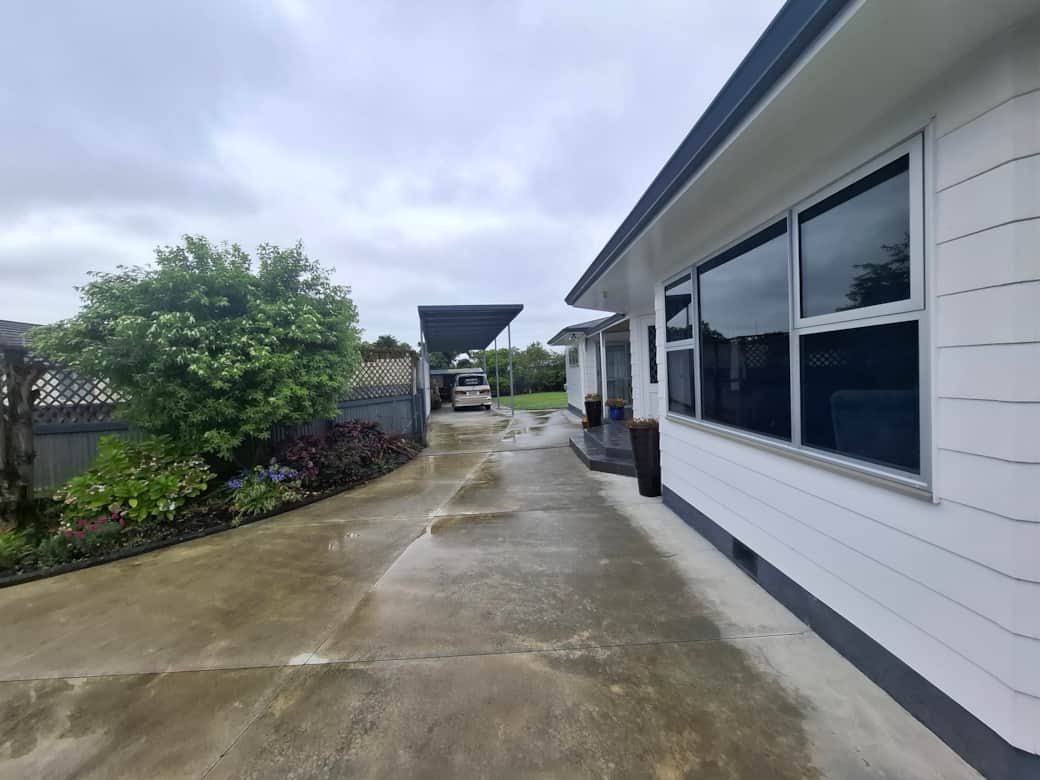 Sheltered carport steps from the front entrance—fits 3 vehicles or car-and-trailer in single file.