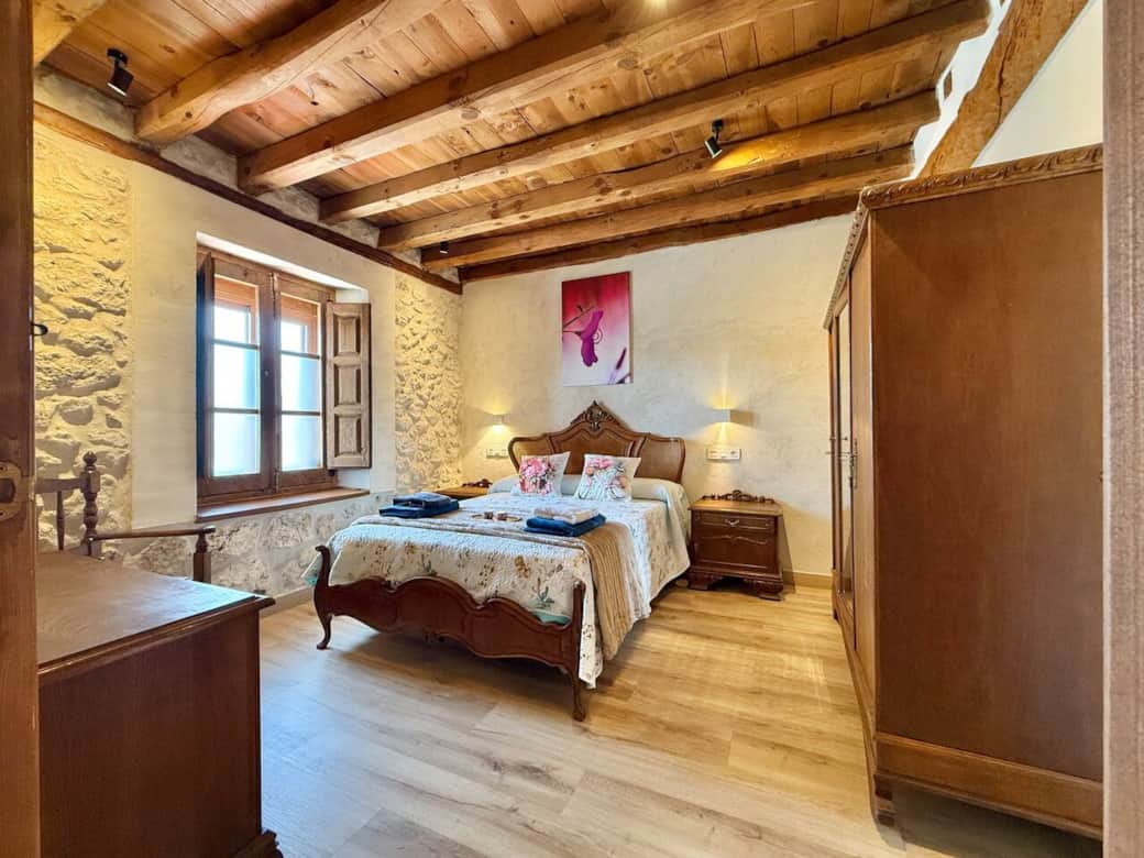 Dormitorio con cama de matrimonio, mobiliario de madera y detalles rústicos que aportan calidez. Un espacio luminoso y cómodo para disfrutar del descanso en un entorno auténtico. Dormitorio con cama de matrimonio, mobiliario de madera y detalles rústicos que aportan calidez. Un espacio luminoso y cómodo para disfrutar del descanso en un entorno auténtico.