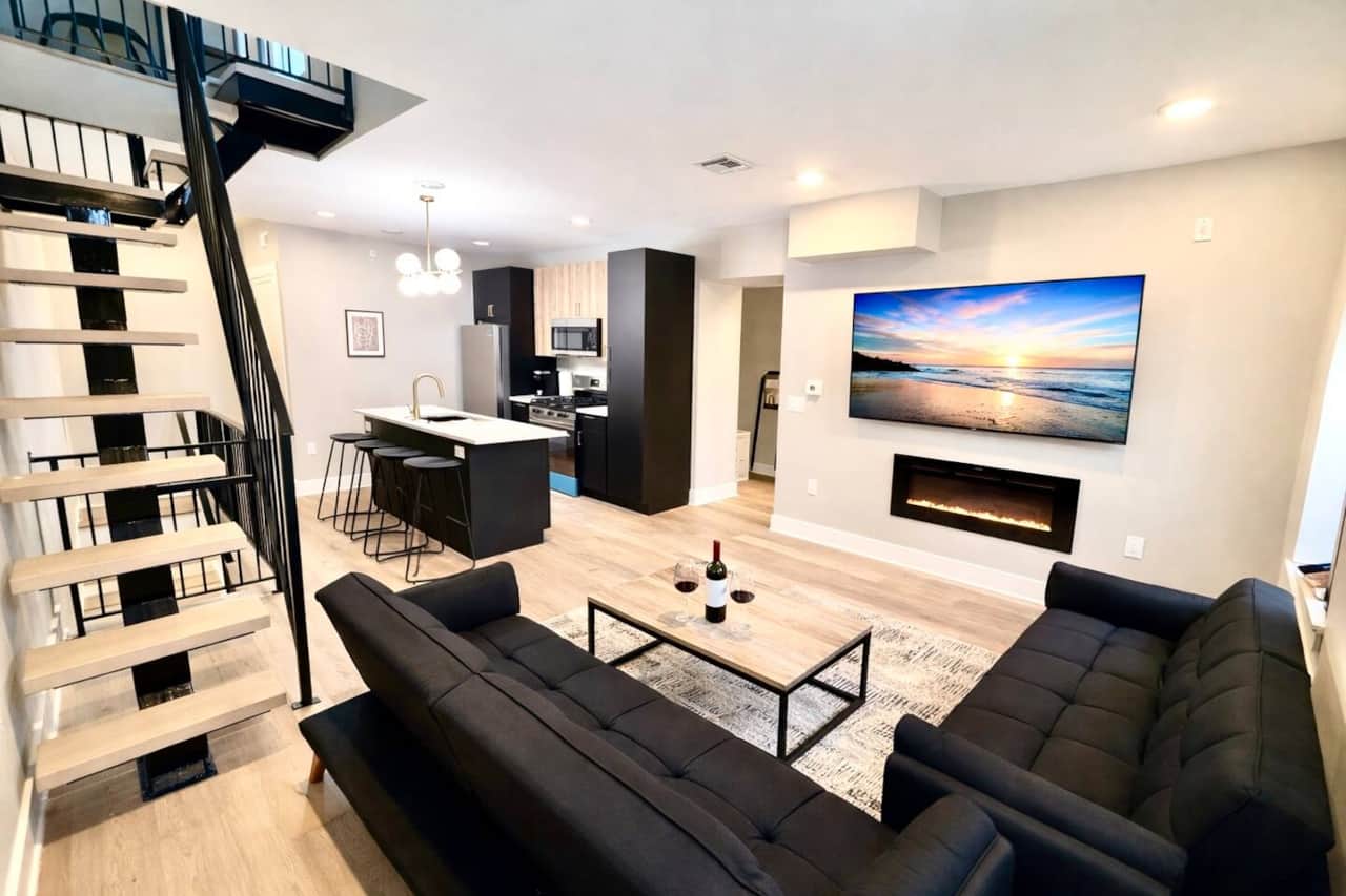 living room with 60 inch TV fireplace two sofa beds and connected to kitchen and Steps up to roof top.