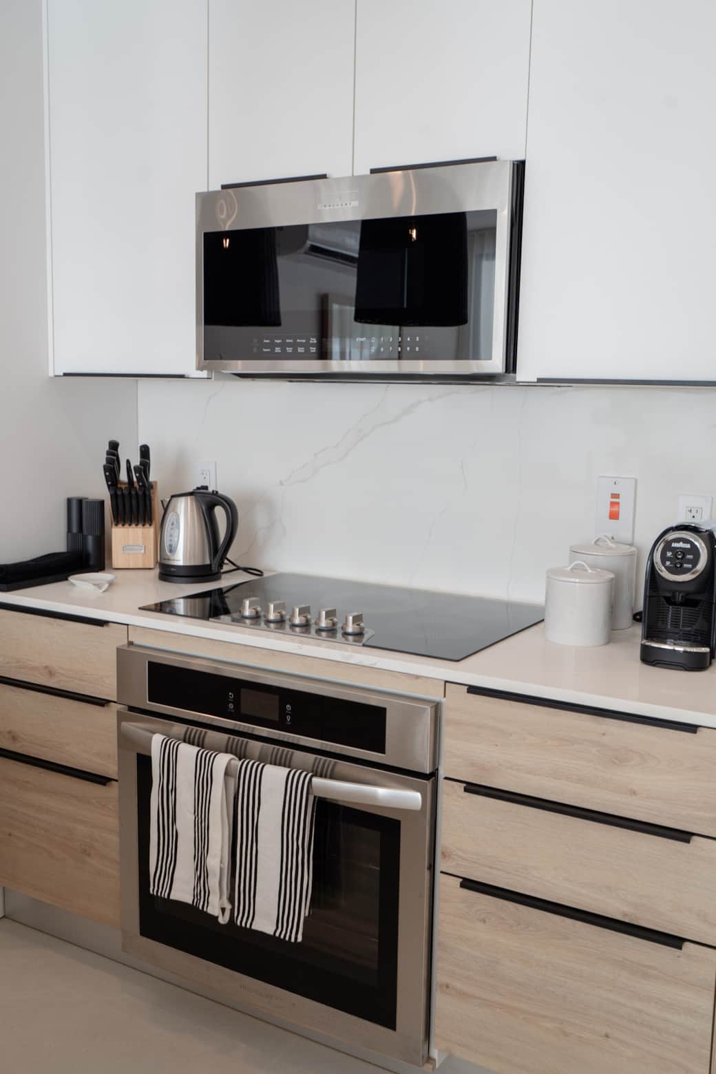 Fully equipped kitchen with stove, oven, microwave, Lavazza espresso maker, and electric kettle.