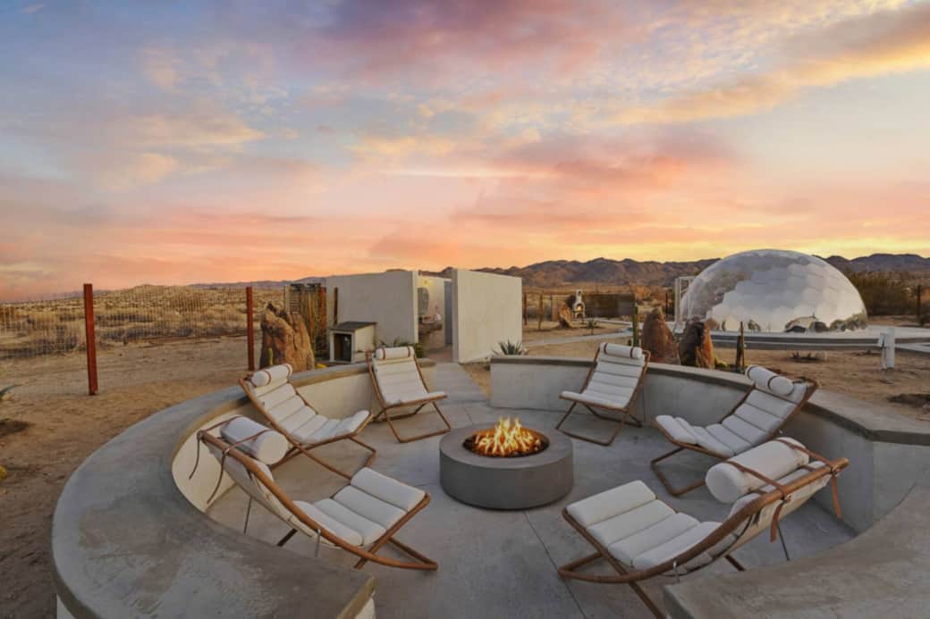 Circular Concrete Fire Pit Scene with Six Luxury Boho Reclining Chairs and Panoramic Desert Views Circular Concrete Fire Pit Scene with Six Luxury Boho Reclining Chairs and Panoramic Desert Views