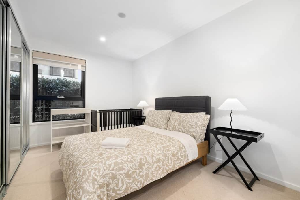 Our bedroom is a haven of comfort. The large bed, with its high headboard and patterned bedding, offers great sleeping experience. The room's bright window reveals a picturesque garden view, while the nightstand and lamp create a functional space.