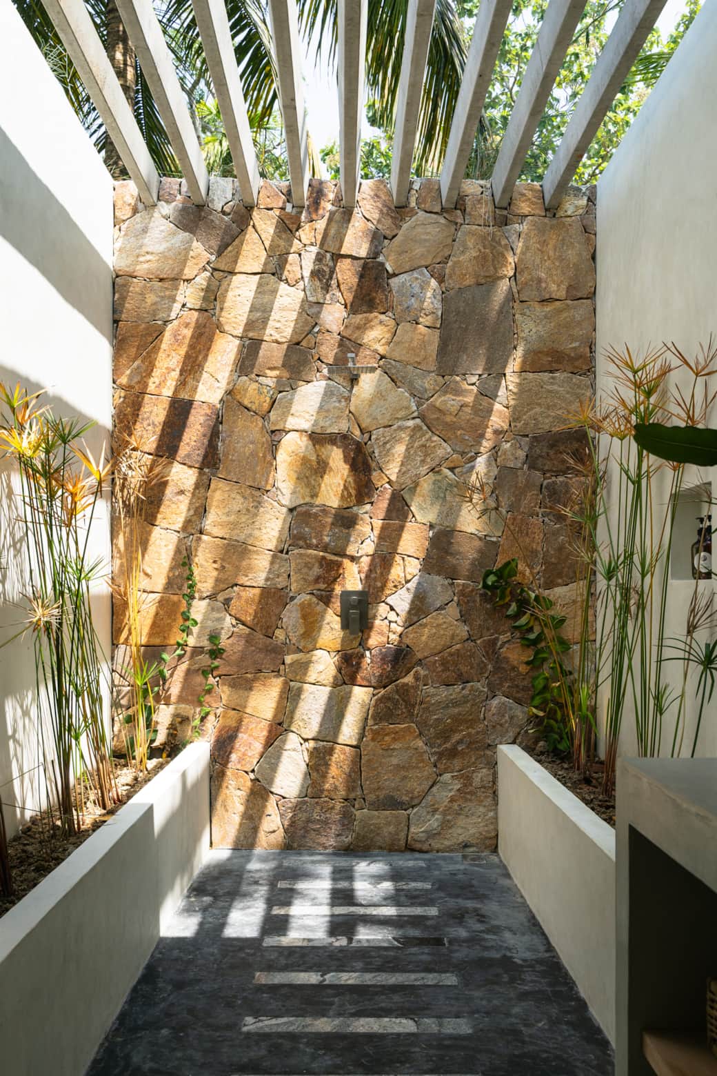 Outdoor shower, sun coming through.