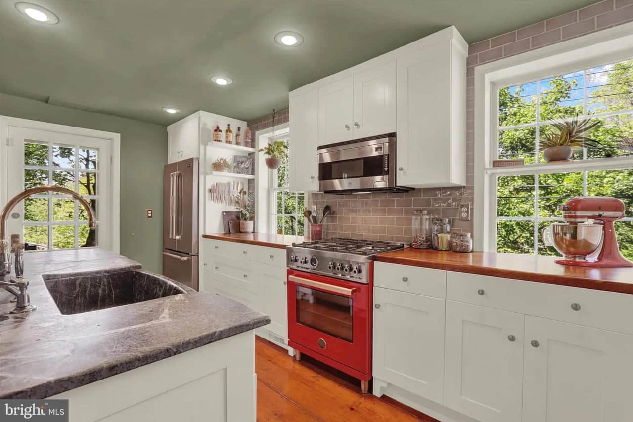 Kitchen with broad soapstone countertops, an inset sink, and a red Bertazzoni range