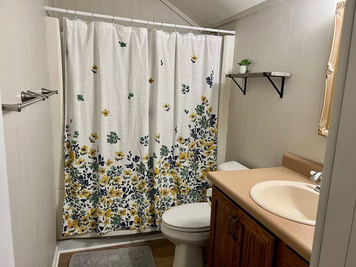 A shared bathroom upstairs with a shower/tub.