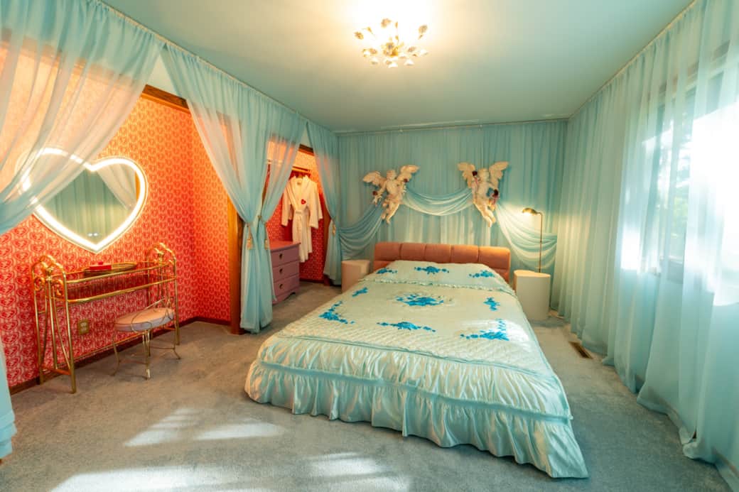 Blue Valentine bedroom with cherub canopy and soft blue drapes