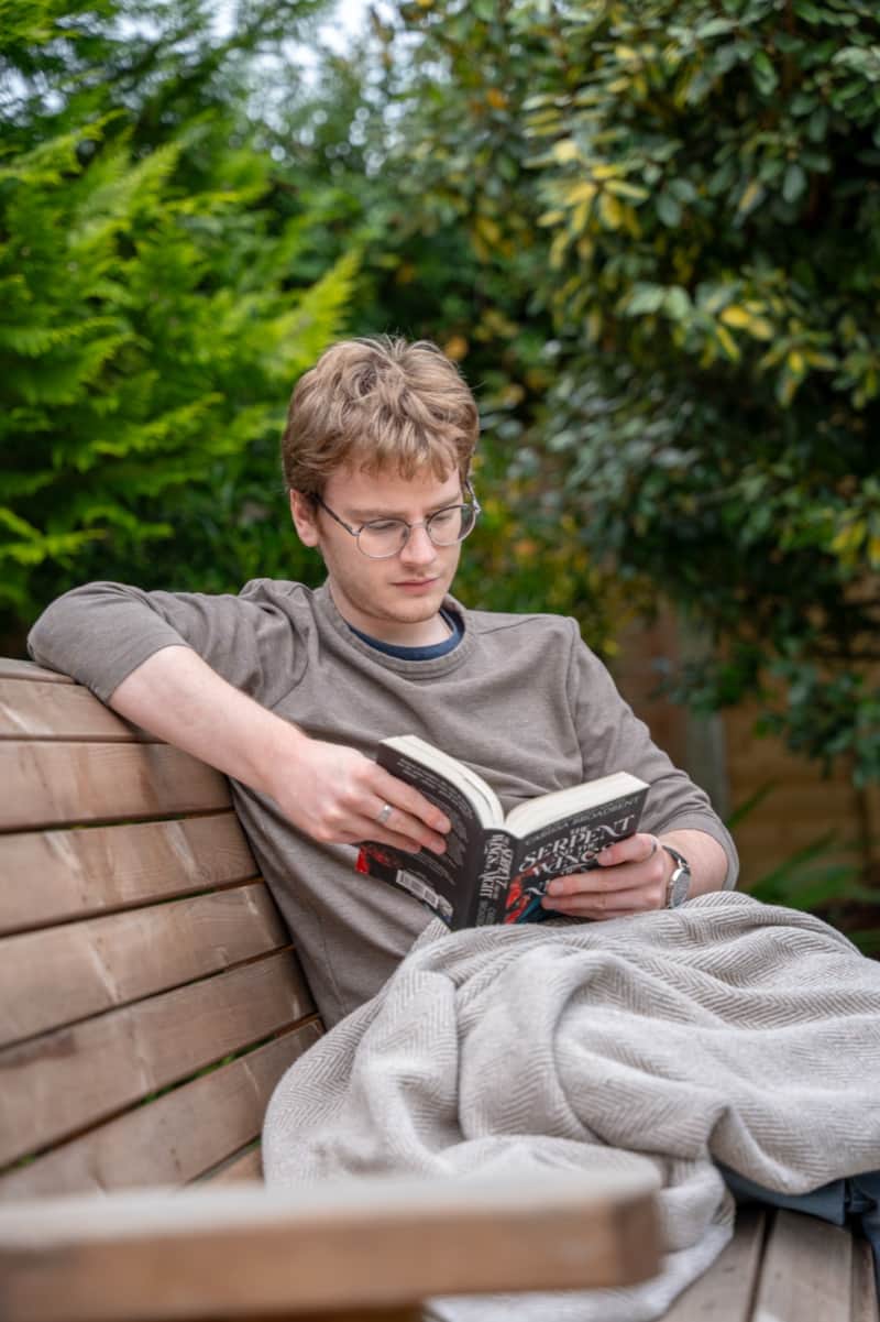 A guest reading a book on a garden bench