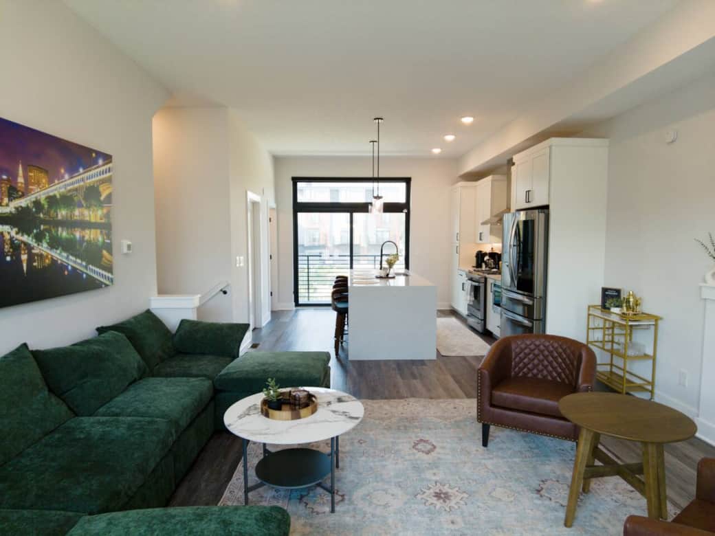 Light-filled living room with floor-to-ceiling windows framing the Cleveland skyline at night.