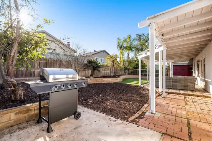 Private backyard with BBQ grill and covered patio for outdoor dining and relaxing.