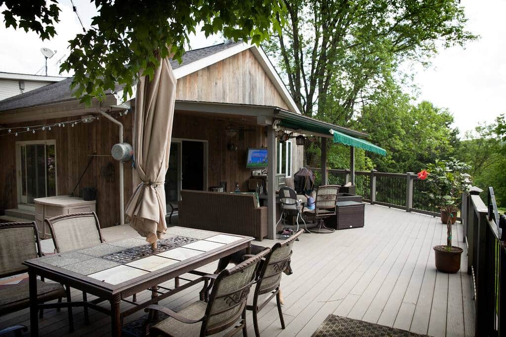 Huge deck has swings, sofas, dining table, outdoor TV and more.