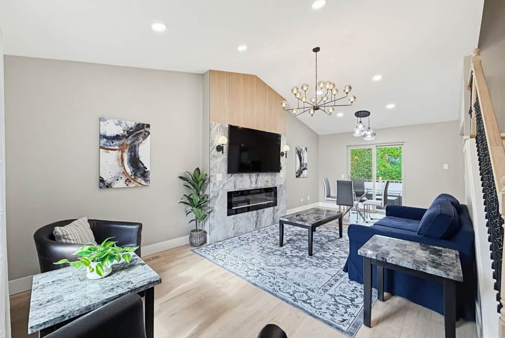 Living Room 1: Sun-drenched main living area with vaulted ceilings and a large flat-screen TV.