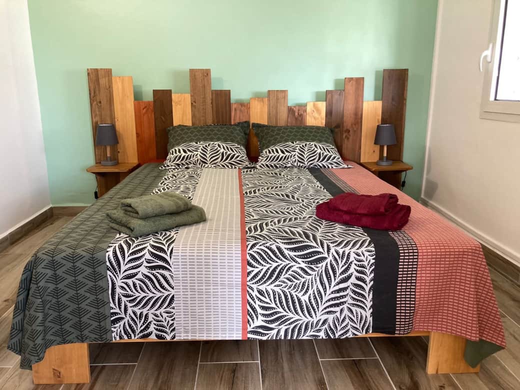 Chambre parentale avec grand lit et décoration bois – Ti ZEINGA la Sainte-Anne