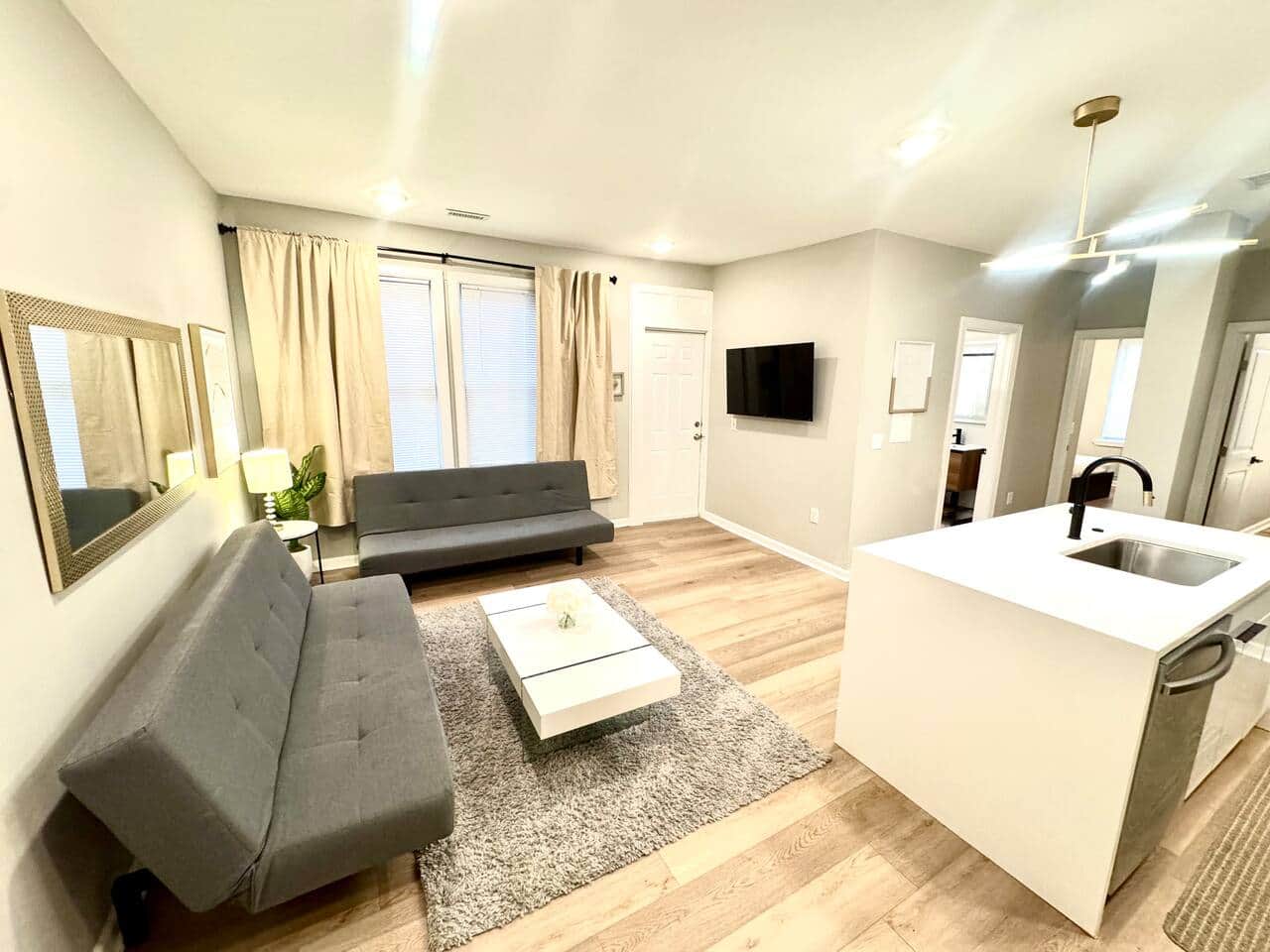 spacious living room! It features 2 futon sofa beds, perfect for accommodating extra guests. Enjoy your favorite shows on the 50-inch TV,  Cozy up by the fireplace underneath for a warm atmosphere. There’s a door that leads to a small balcony outside