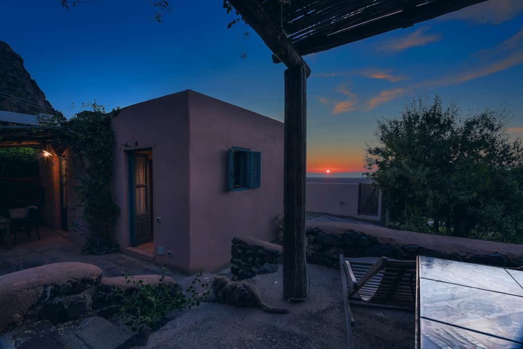 Casetta rosa al tramonto a Pollara, atmosfera unica e silenzio sulle Eolie.