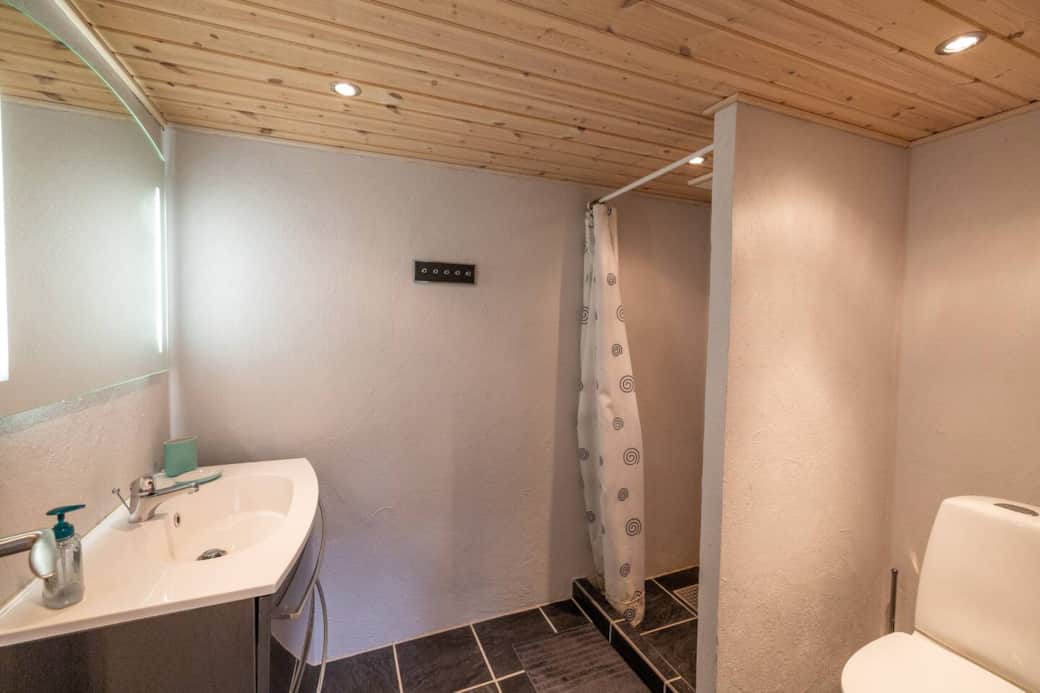 Badeværelse med bruser og toilet