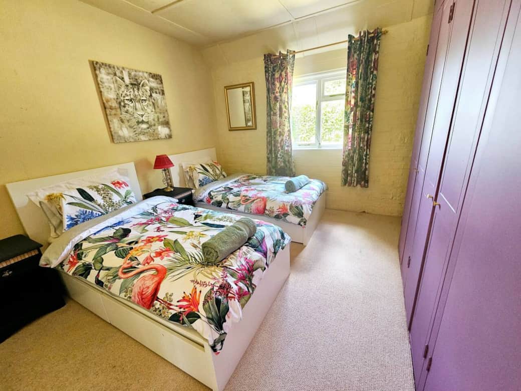 Twin room with fitted wardrobes and garden view.