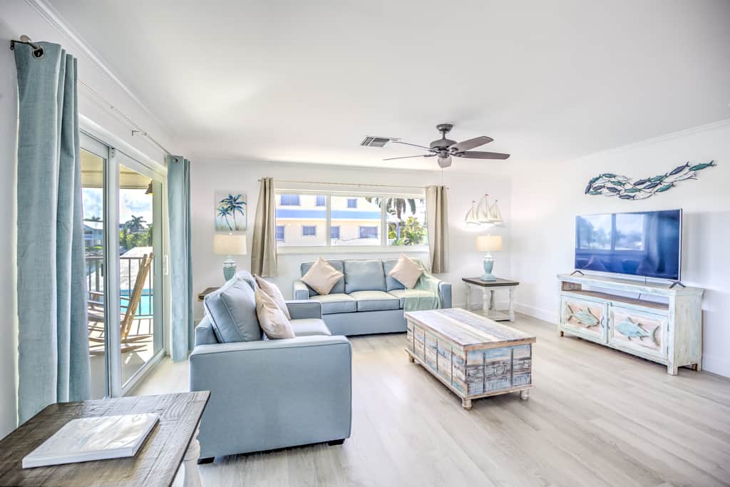 Come in from the water to a bright coastal living room with the balcony slider right there. Smart TV