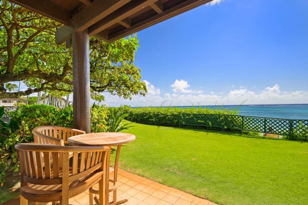 Expansive oceanfront lanai offering unobstructed coastal views and peaceful outdoor dining in a lush