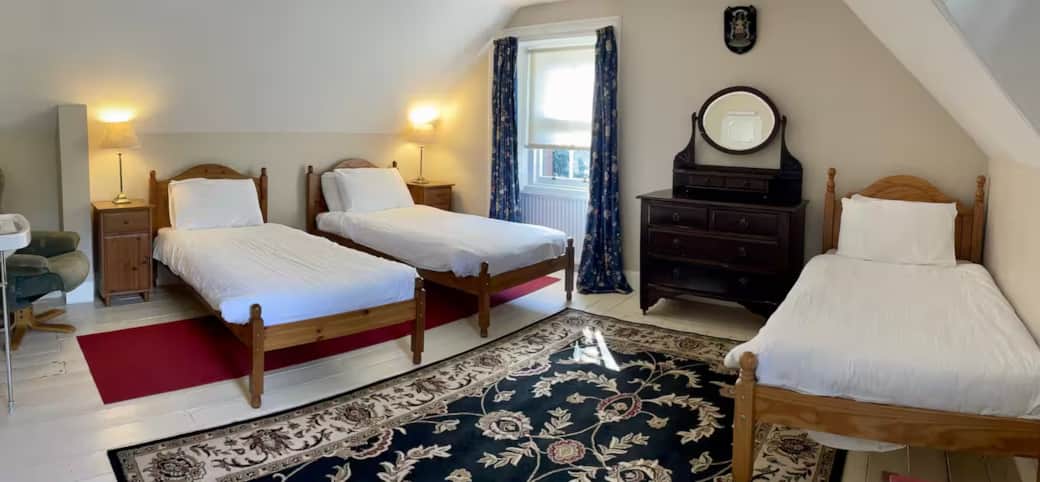 A triple bedroom on the first floor with double aspect windows. A large room with sink (just seen in