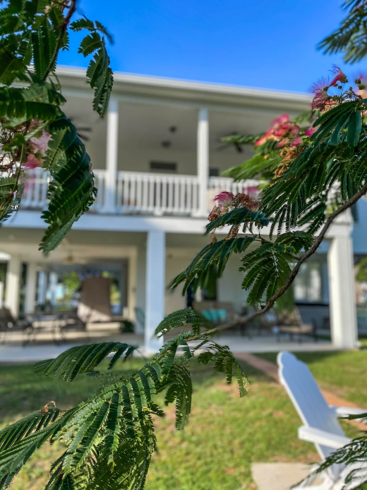 Classic white coastal exterior, accented by sea-salt green shutters, exudes timeless appeal.