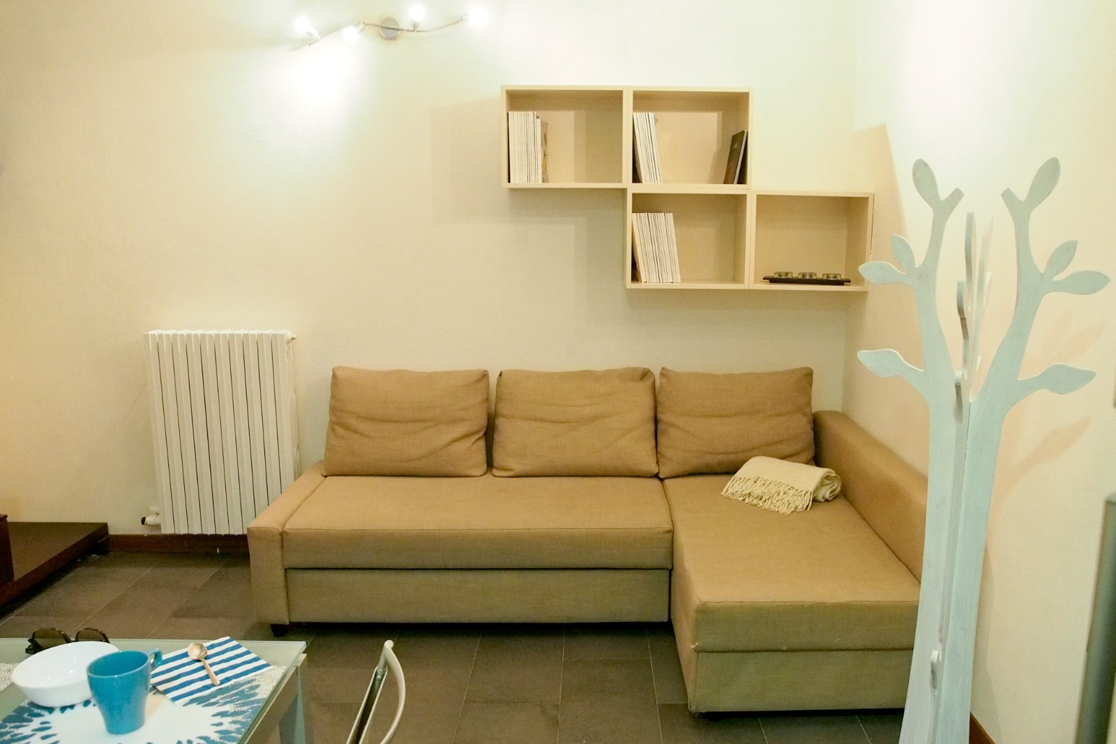 Soggiorno con cucina attrezzata, tavolo in vetro e luce naturale