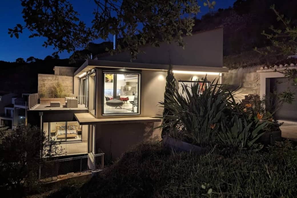 La maison dévoile une autre facette une fois la nuit tombée. Un éclairage extérieur chaleureux valorise l’architecture contemporaine et sécurise les déplacements.