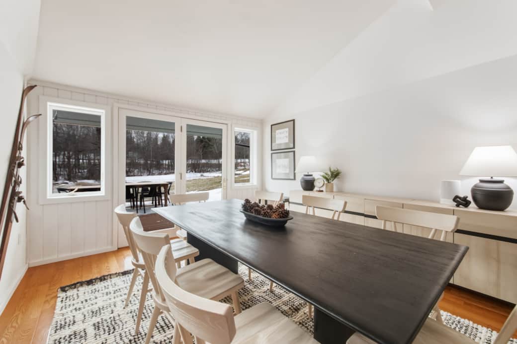 Sun-filled living room with expansive windows and forest views Sun-filled living room with expansive windows and forest views