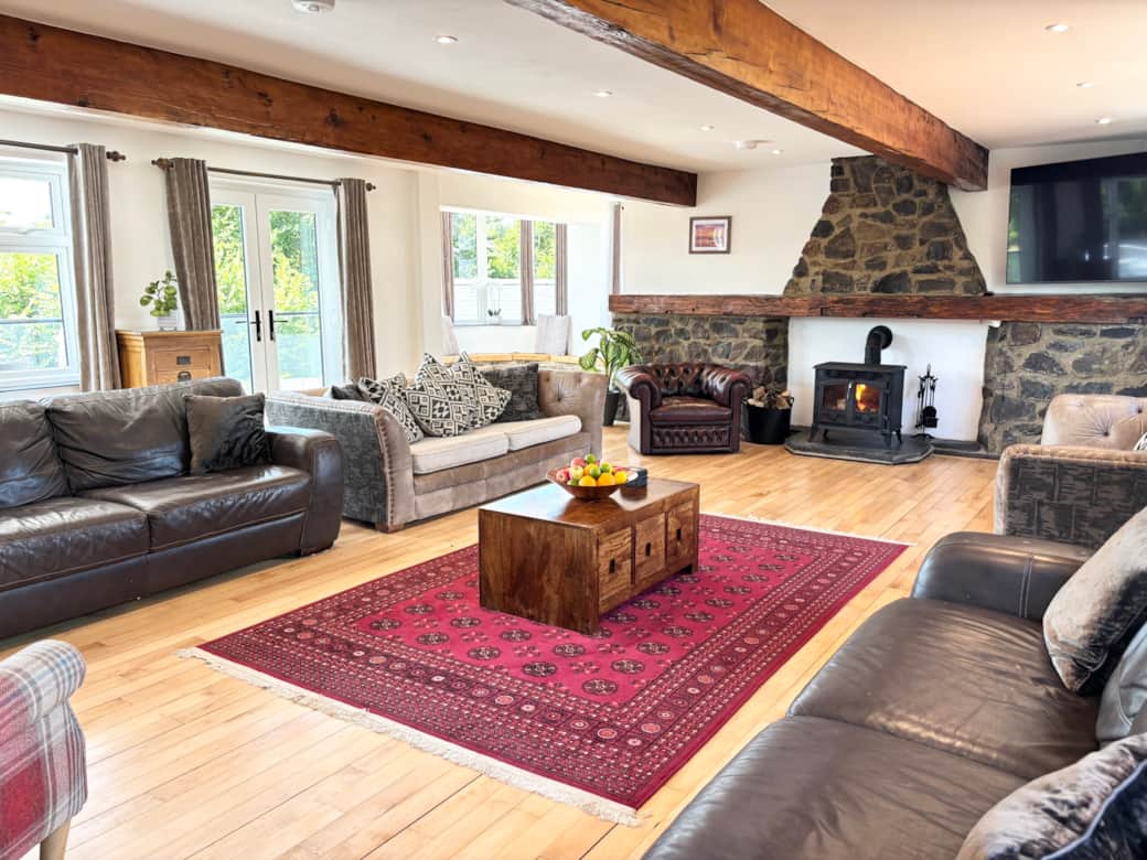 Living Room with 63” smart TV and log burner - balcony overlooking the pool 
