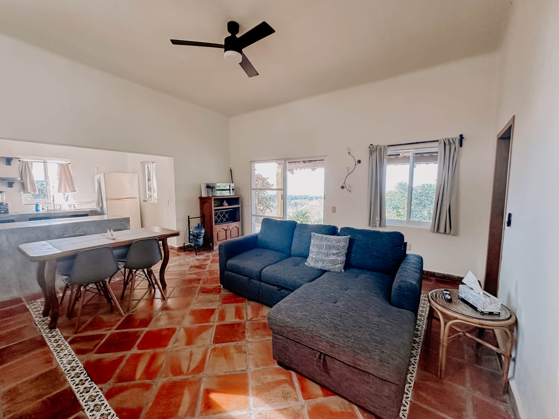 Living room with sofa, ceiling fan and open kitchen at La Casa Chilam
