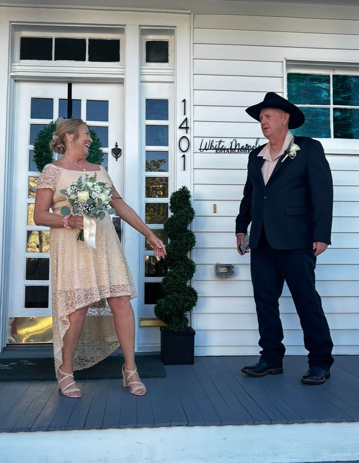 Bride and groom celebrating their wedding on the front porch of White Magnolia Galveston