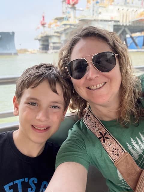 Mom and son smiling together on a ferry ride in Galveston