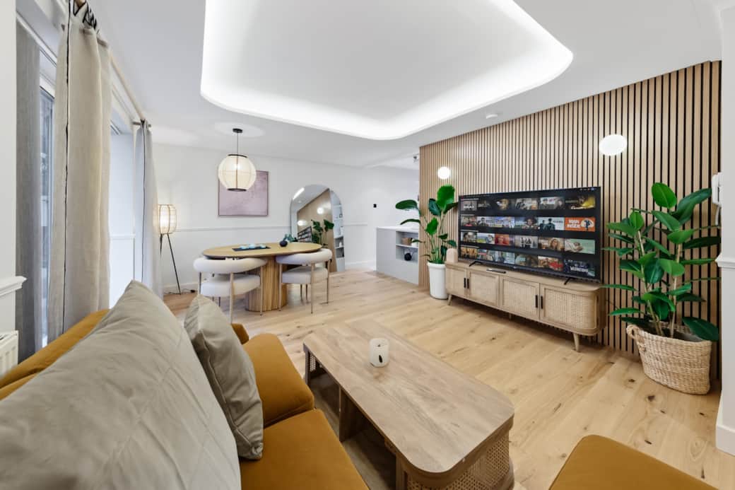 Open living space with feature wall, media unit, dining area and light wood flooring throughout Open living space with feature wall, media unit, dining area and light wood flooring throughout
