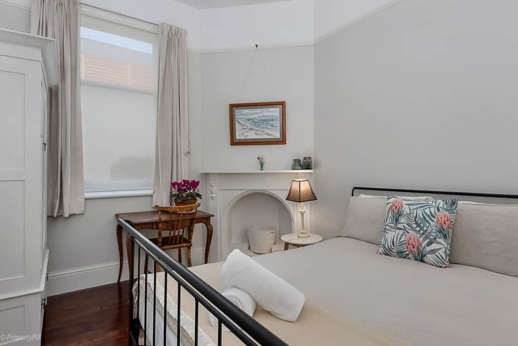 Bedroom two has a queen sized bed and writing desk.