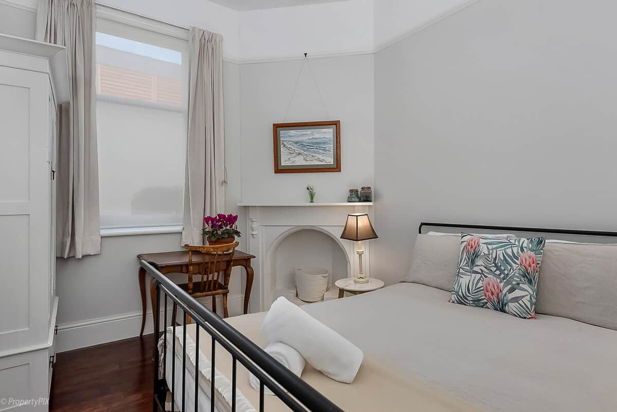 Bedroom two has a queen sized bed and writing desk.