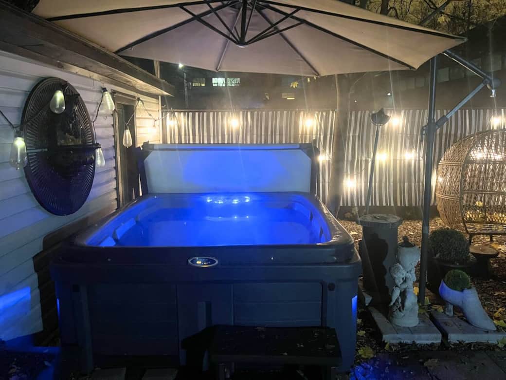 Shared backyard oasis featuring a luxury hot tub & ambient lighting
