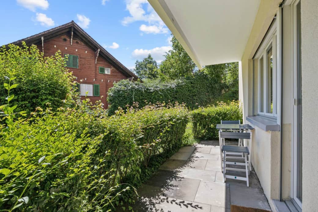 Private, sunny terrace with seating, surrounded by lush greenery. Private, sunny terrace with seating, surrounded by lush greenery.