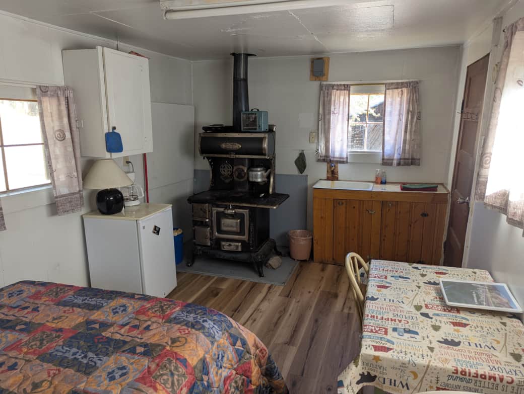 Cabin 9 is a cozy rustic cabin that features a wood-burning stove.
