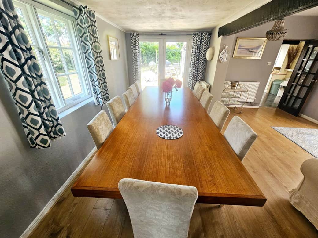 Large bright dining area with a table to comfortably seat up to 12.