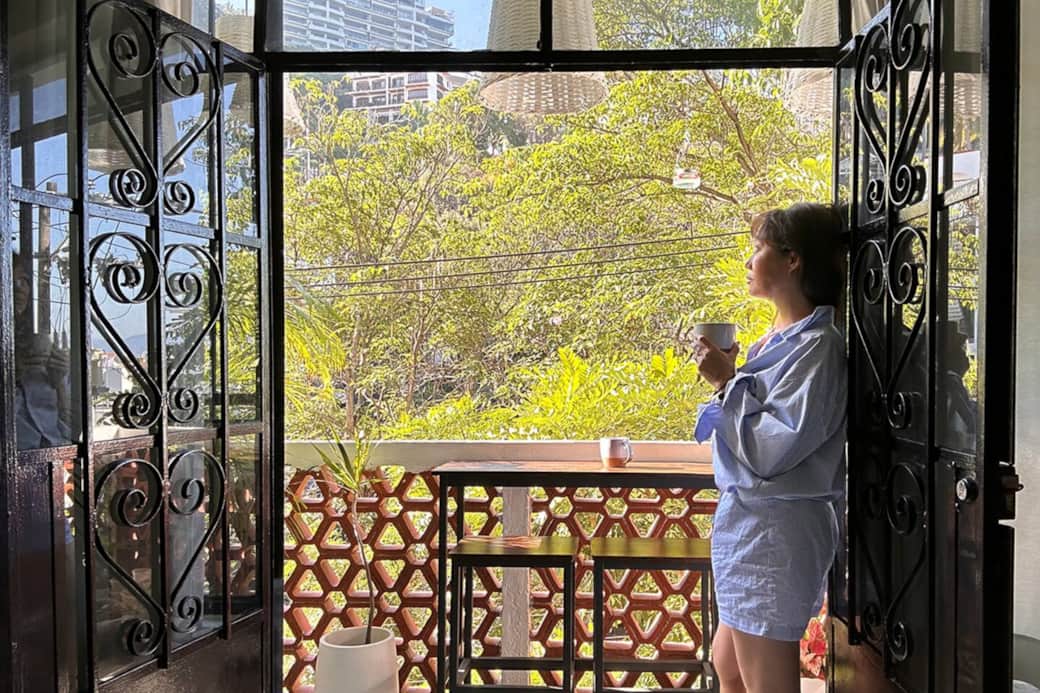 Start your day with coffee on the balcony—sunlight, greenery, and a quiet neighborhood rhythm just beyond your door.