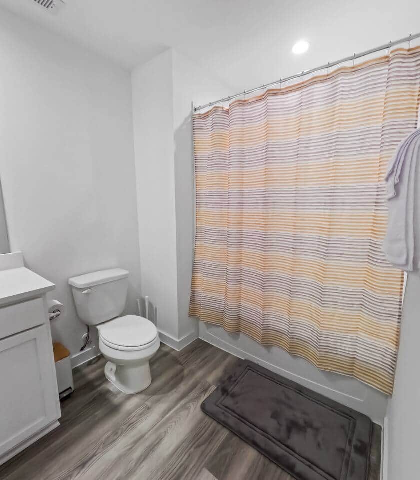 Bright full bathroom with a tub/shower combo, fresh towels, and modern finishes. Clean, functional, and stocked with essentials for a comfortable stay.