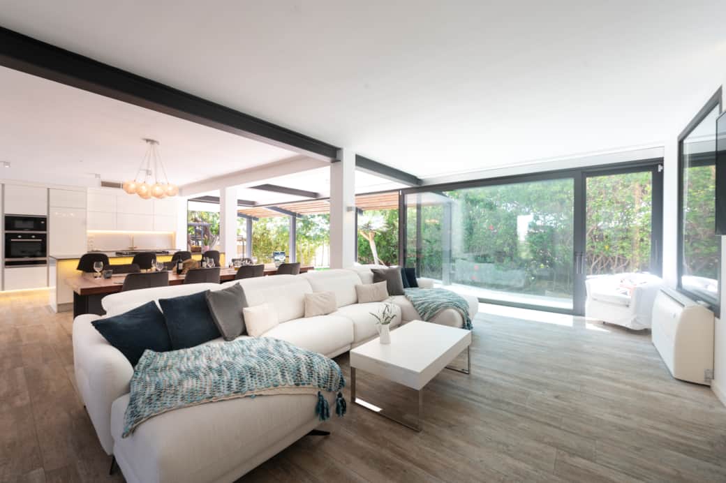 Living room with large windows opening to the garden at Casa Guindilla in Portals Nous, Mallorca