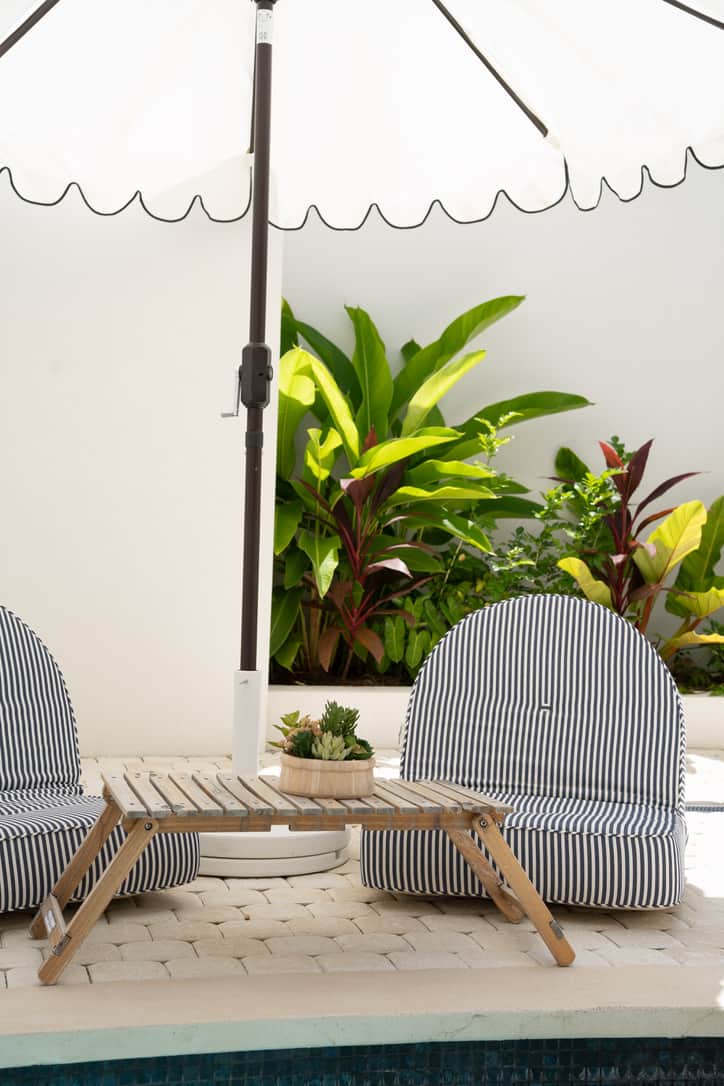 Private plunge pool surrounded by lush greenery and sun loungers.
