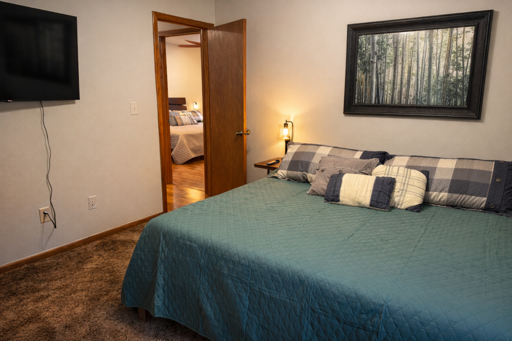Spacious California king bedroom with 50″ Roku TV and closet storage.