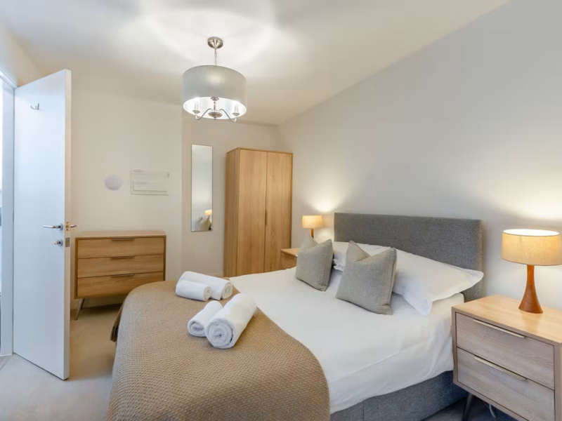 Double bedroom with bedside lamps and a wardrobe
